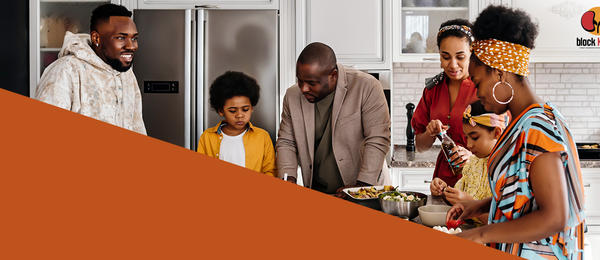 Image of a family gathered in the kitchen, smiling and laughing